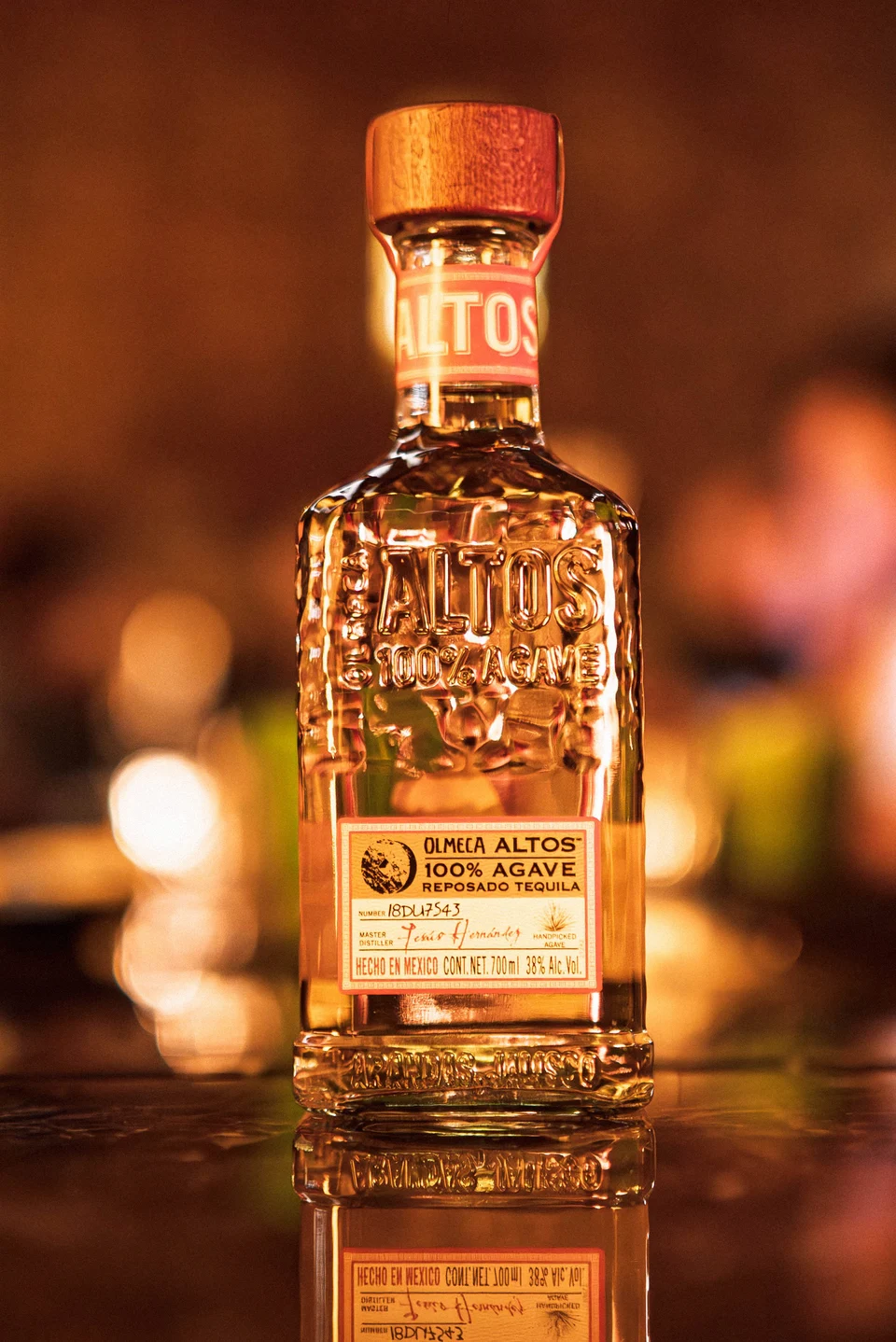 Amber spirit bottle on reflective bar