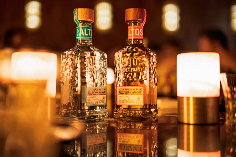Paired spirit bottles between warm lamps