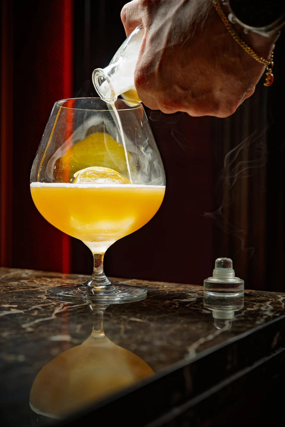 Golden cocktail pour over reflective bar