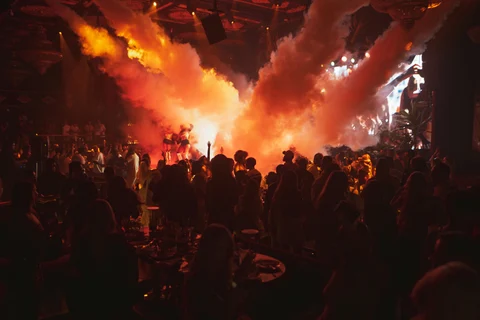 Amber smoke burst over nightclub crowd