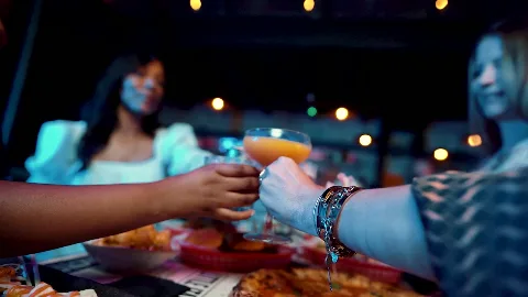Guests raising drinks around a restaurant table.
